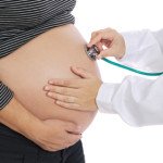 Pregnant examined by a doctor a over white background